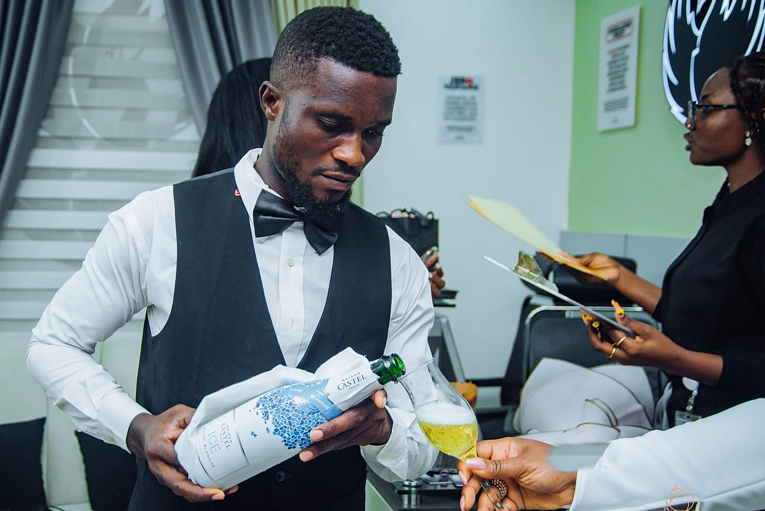 Bartender pouring drink at stylish event.