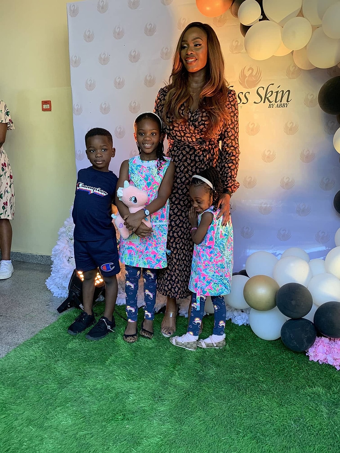 Family photo at an event with colorful backdrop.