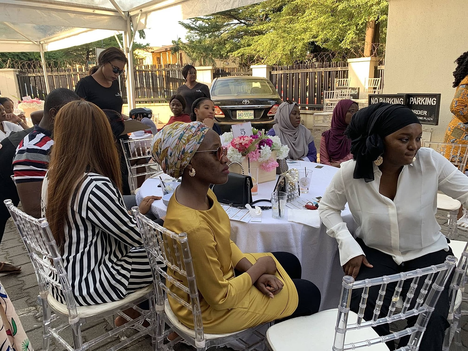 Outdoor gathering with people at decorated tables.