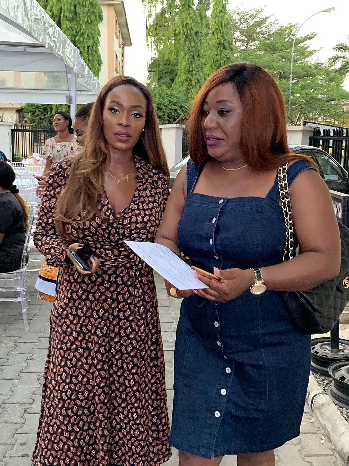 Two women engaged in conversation outdoors.