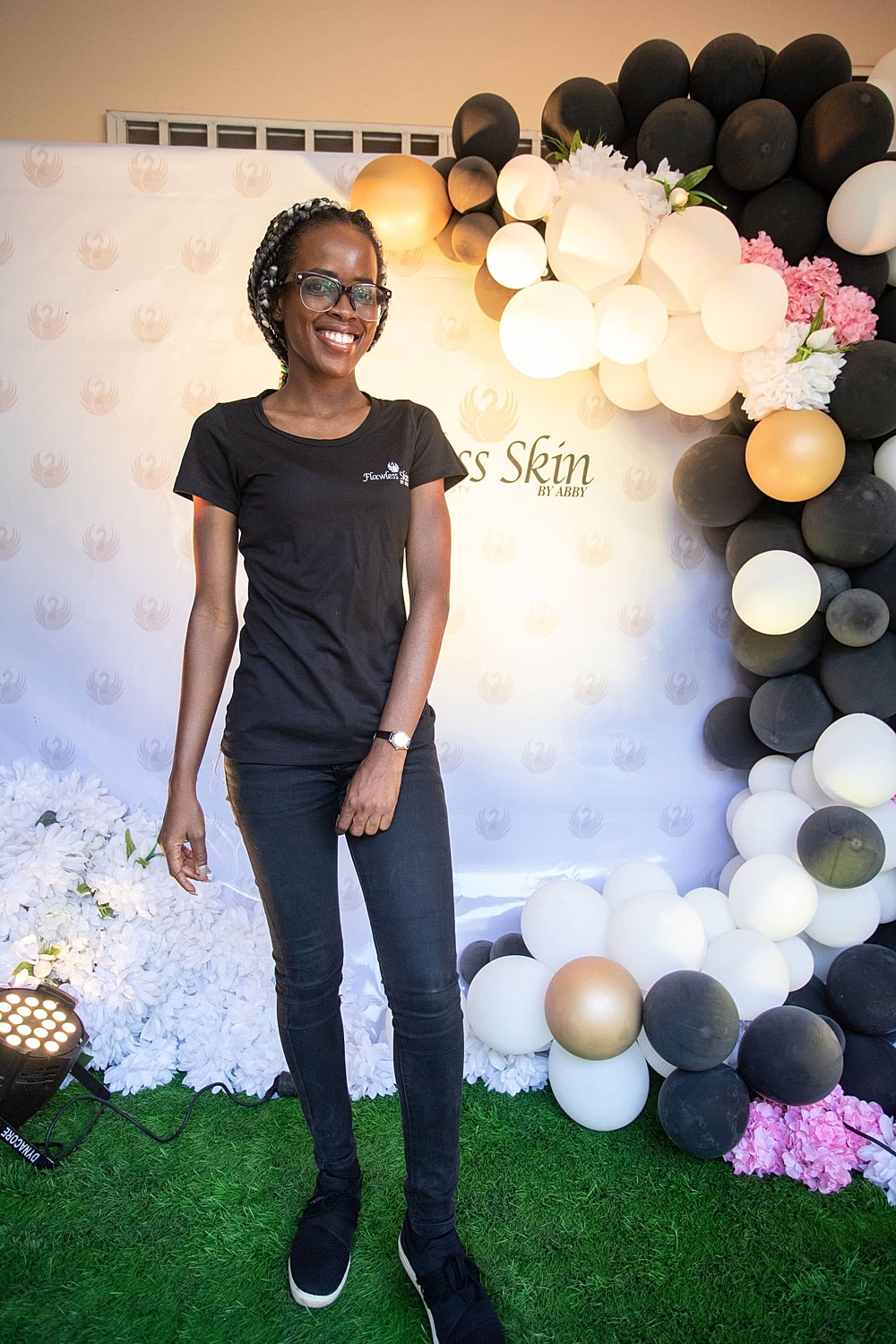Woman smiling in front of a balloon backdrop.