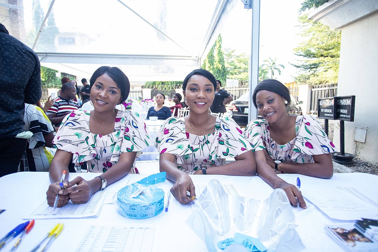 Smiling women at an event registration table.