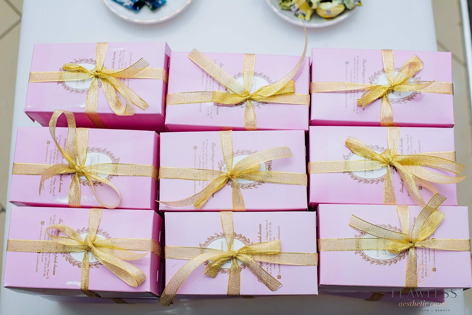 Pink gift boxes with golden ribbons arranged neatly.