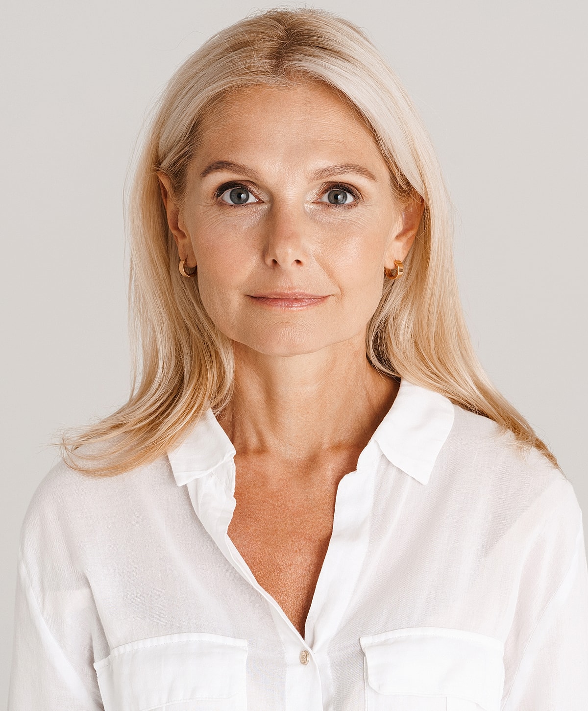 Abuja Laser Treatment model with long blonde hair in white shirt.