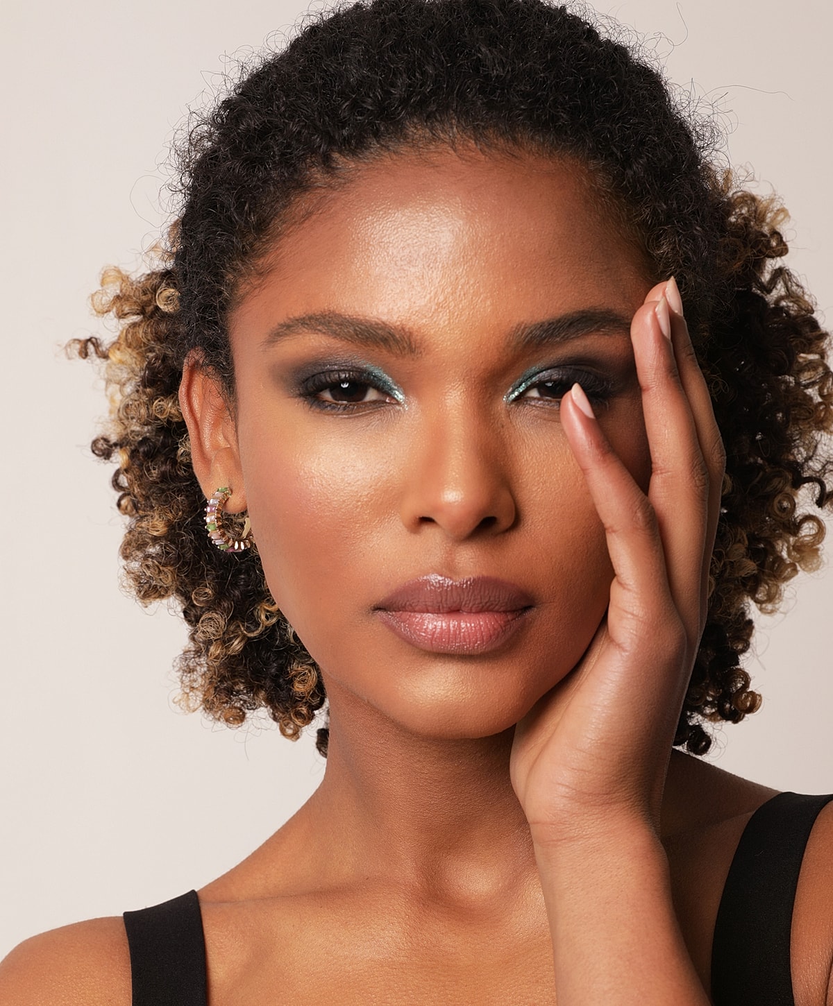 Woman with curly hair and glamorous makeup.