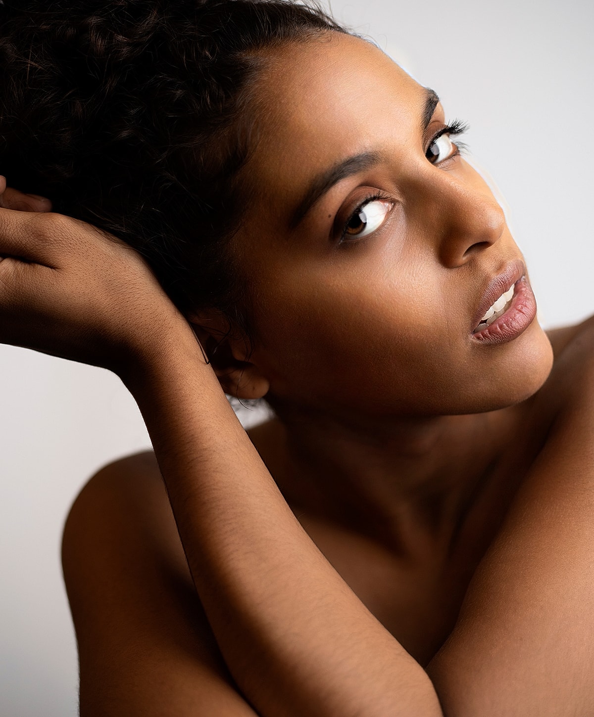 Abuja PDO Thread Lift model with a soft expression and curly hair.