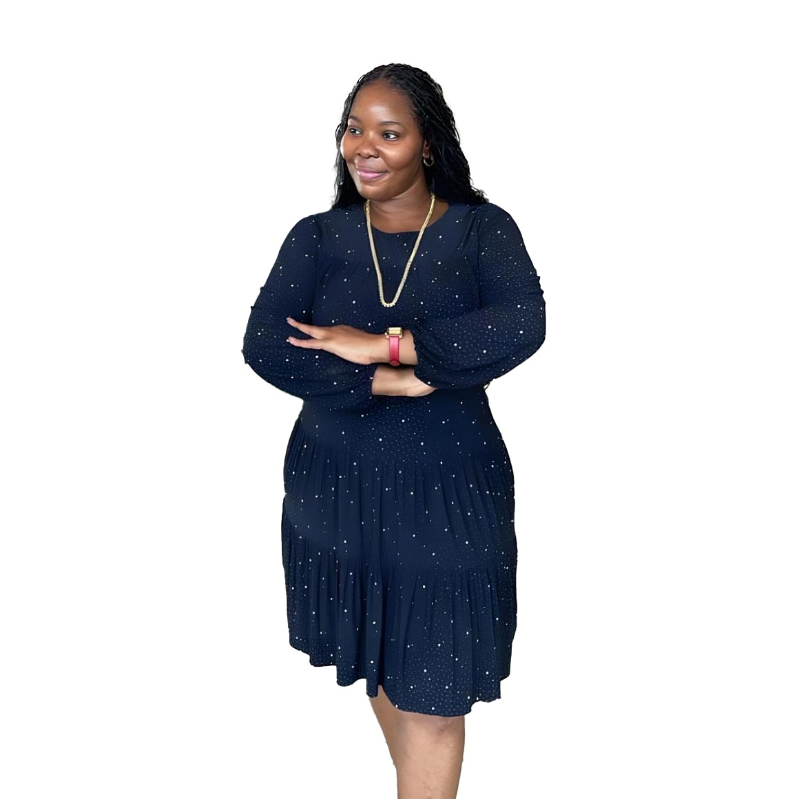Smiling woman in polka dot dress, arms crossed.