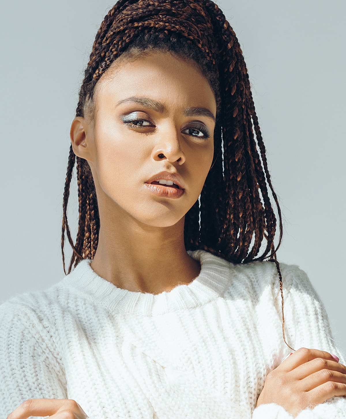 Abuja Facelift model with beautiful skin and red nail polish.