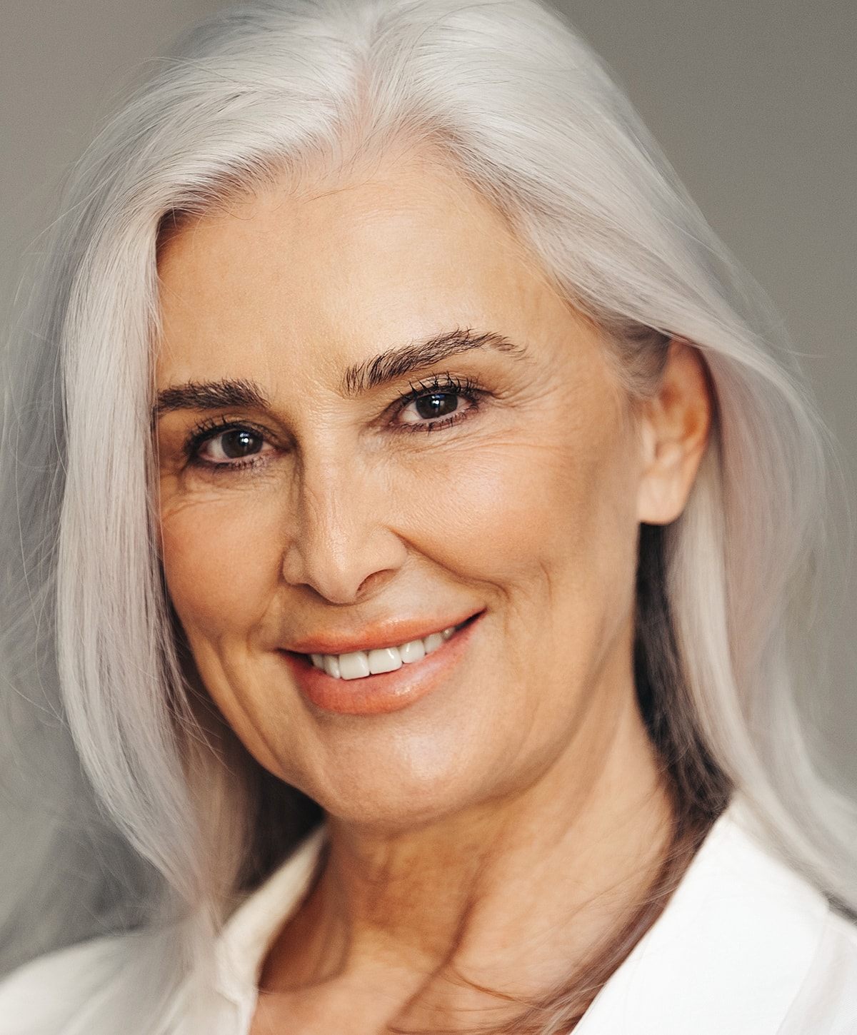 Smiling older woman with long silver hair.