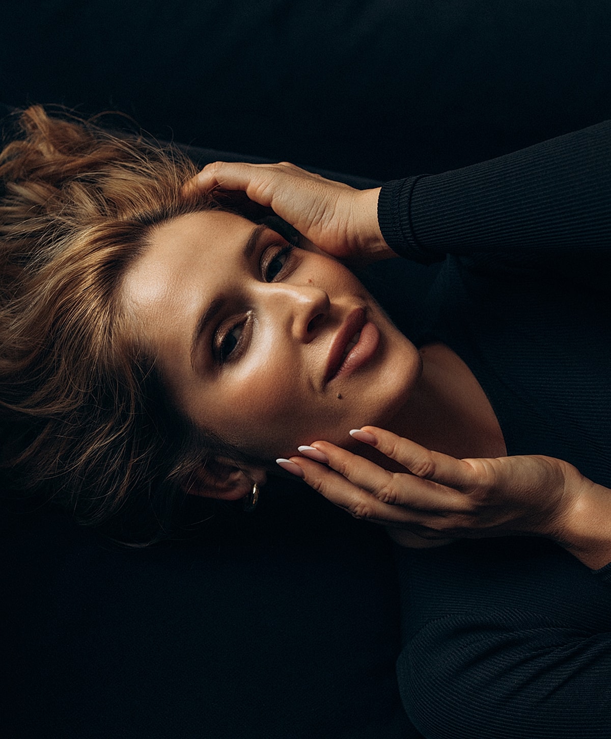 Woman resting with hands in her hair.