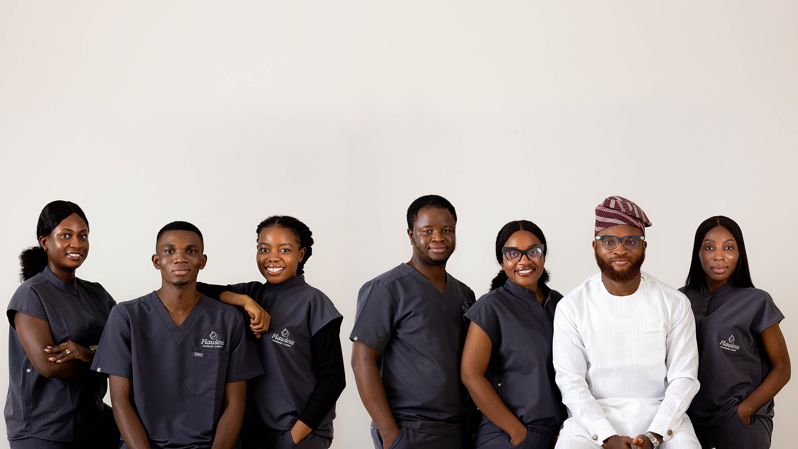 Six professionals posing in front of a building.